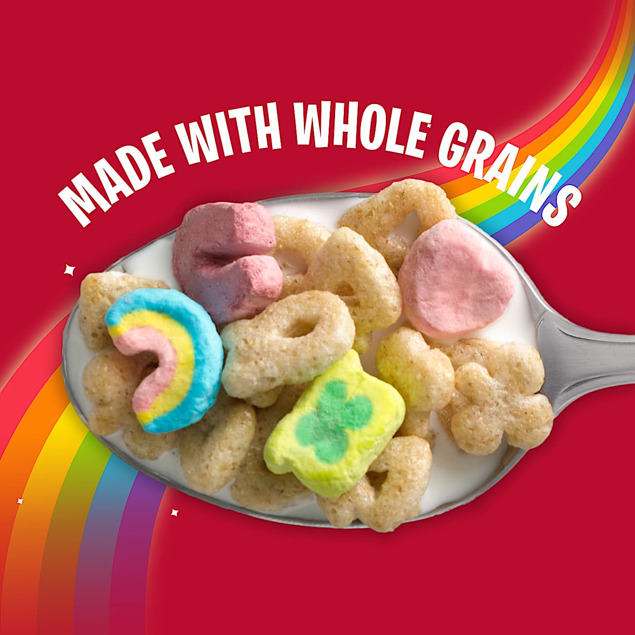 A spoon full of Lucky Charm cereal pieces with a rainbow flowing behind it