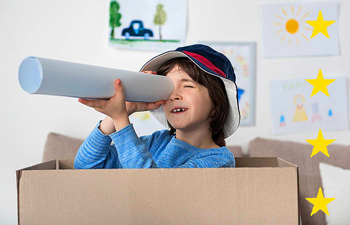 Young Boy in a box with a paper telescope