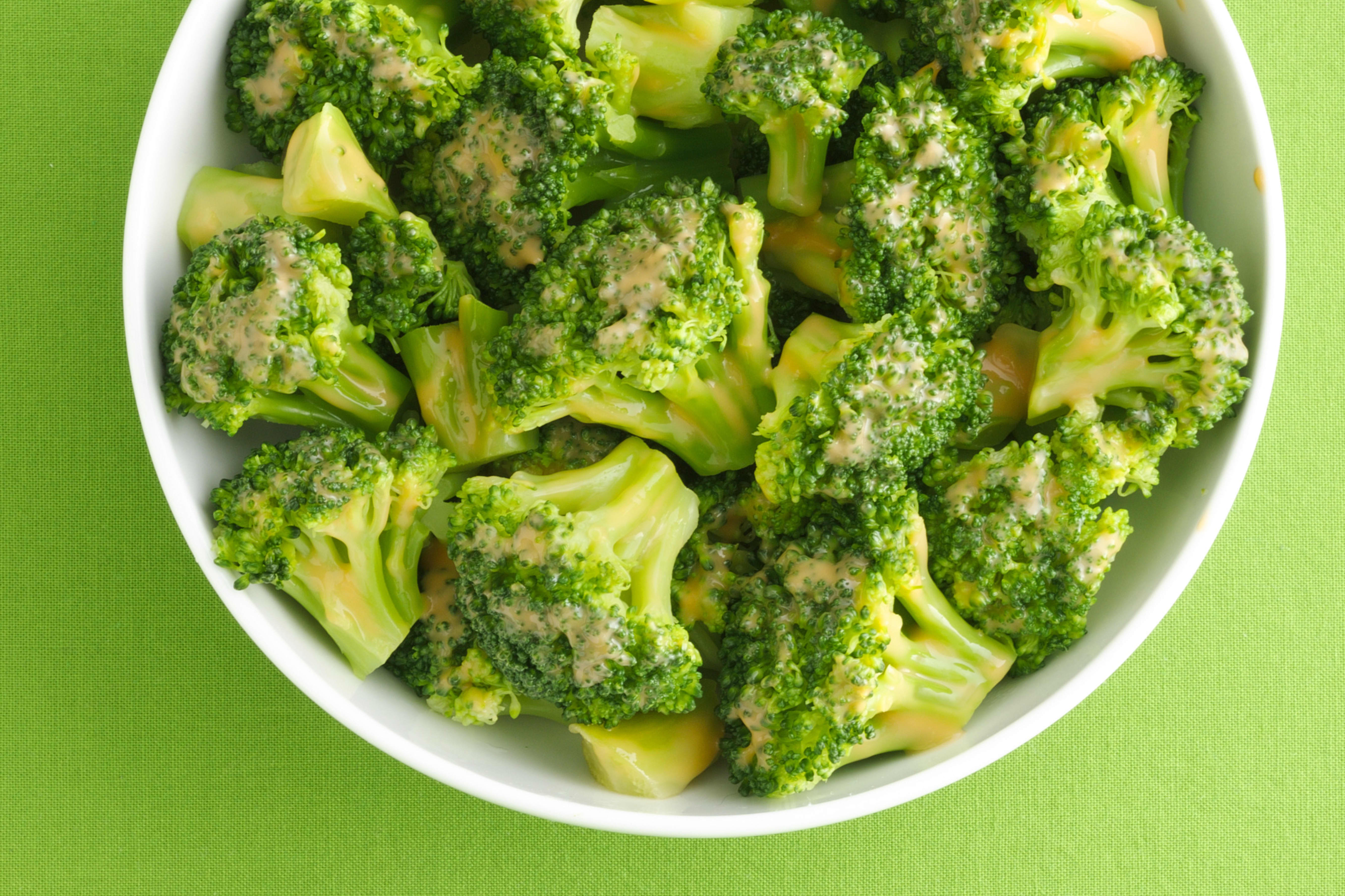 Bowl of broccoli drizzled with cheese