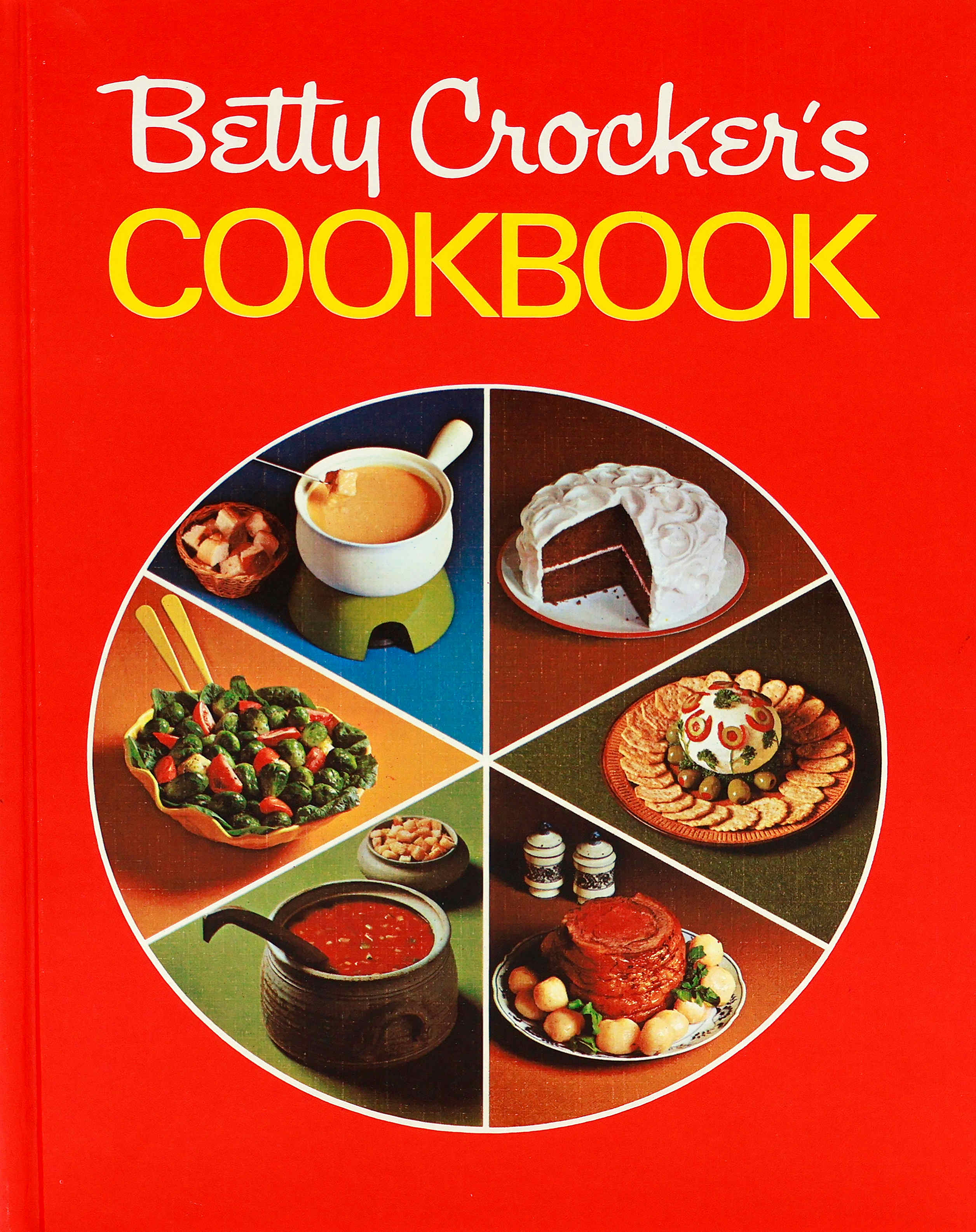 Cover of the 1969 Betty Crocker Cookbook with a red cover that has a circle on it cut into wedges like a pie.  The 6 wedges contain: fondue pot; chocolate cake, cheeseball with crackers, rib roast surrounded by small whole potatoes, soup, and a salad with brussels sprouts and tomato wedges.