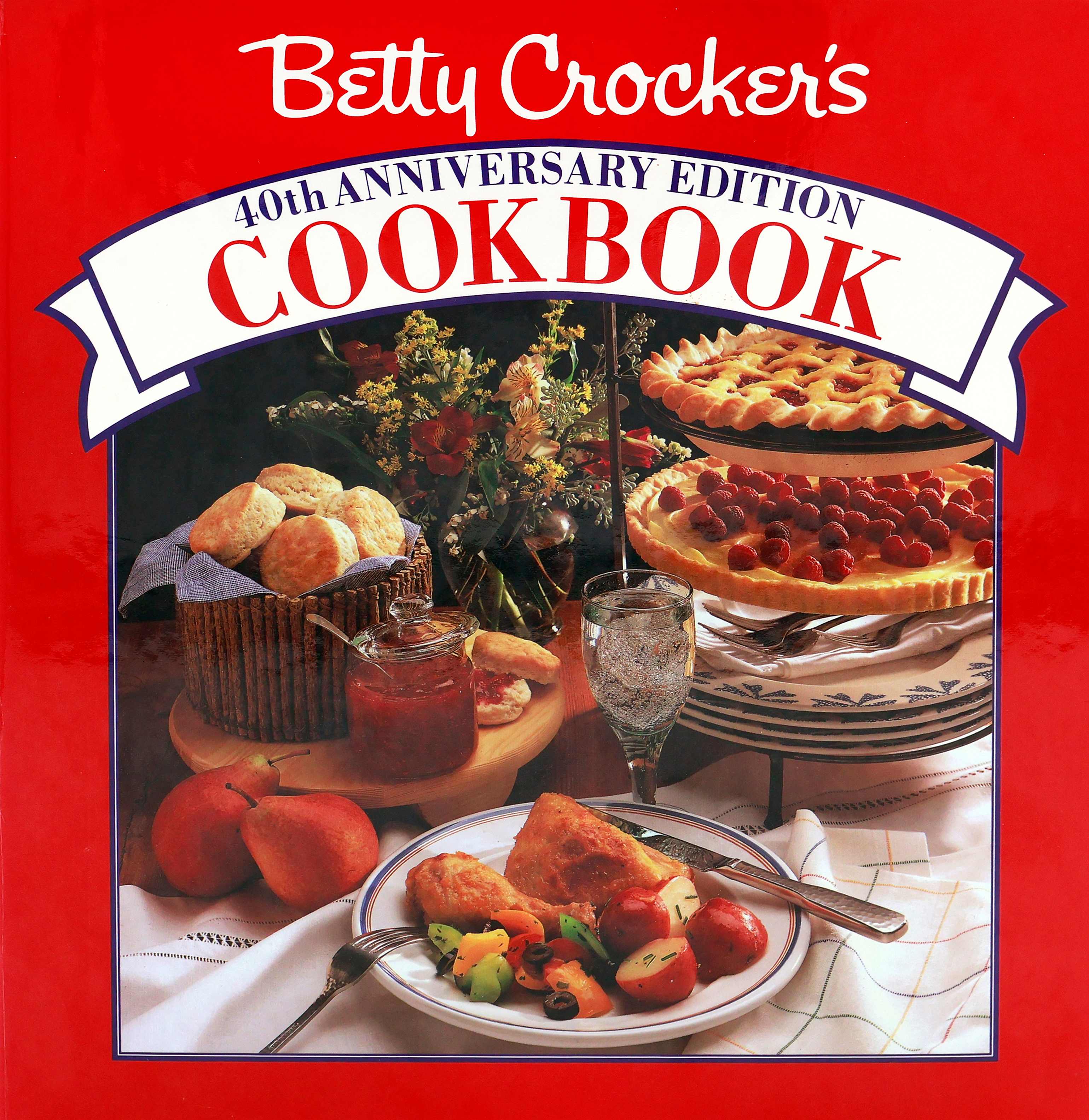 Cover of the 1991 Betty Crocker Cookbook with a red cover that has a “40th Anniversary” banner with square below with plate of roast chicken and small red potatoes, biscuits and jam, vase of flowers, and a tiered plate holder with plates on the lowest tier; a tart on the 2nd tier; cherry pie on the top tier.