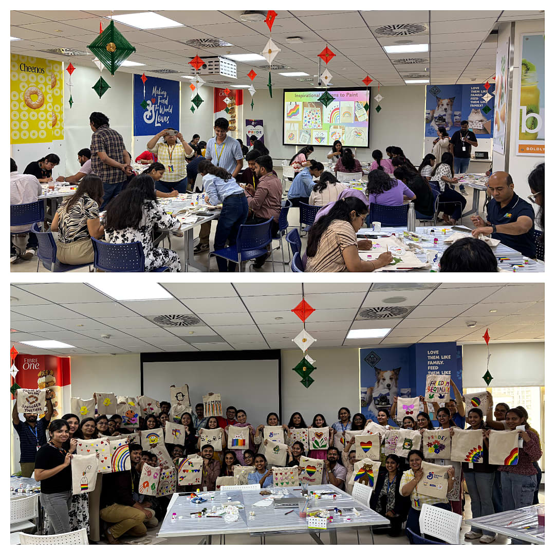 A collage of two photos from an indoor craft workshop. The top photo shows a large group of participants seated at tables, painting and decorating cloth bags with colorful designs. The room is decorated with hanging ornaments, and a presentation screen at the front displays drawings featuring rainbows and Pride-themed art. The bottom photo shows the same group standing together and holding up their finished cloth bags, each decorated with different rainbow patterns, symbols, and creative artwork. The tables in the foreground are covered with art supplies and craft materials.