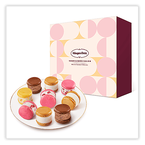 A plate of assorted Häagen-Dazs macaron ice cream sandwiches placed in front of a decorative box with a geometric design in pink, peach, and burgundy. The box features the Häagen-Dazs logo and the text "Macaron Sandwich Collection" in English and Chinese.