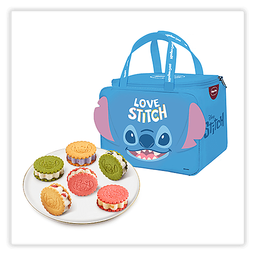 A blue lunch bag with a design of Stitch from Disney's "Lilo & Stitch" and the text "LOVE STITCH" on the front, featuring two handles and a zipper closure. Beside the bag is a white plate holding six colorful sandwich cookies in green, yellow, red, and pink, each with unique designs.