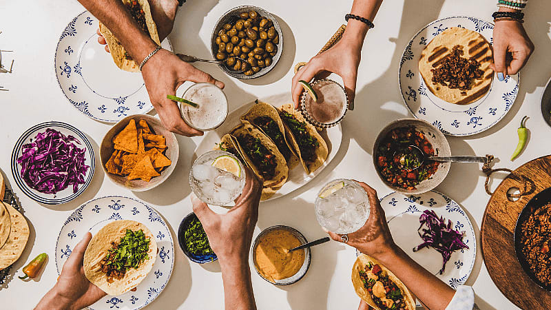 group of people celebrating & enjoying party food on table
