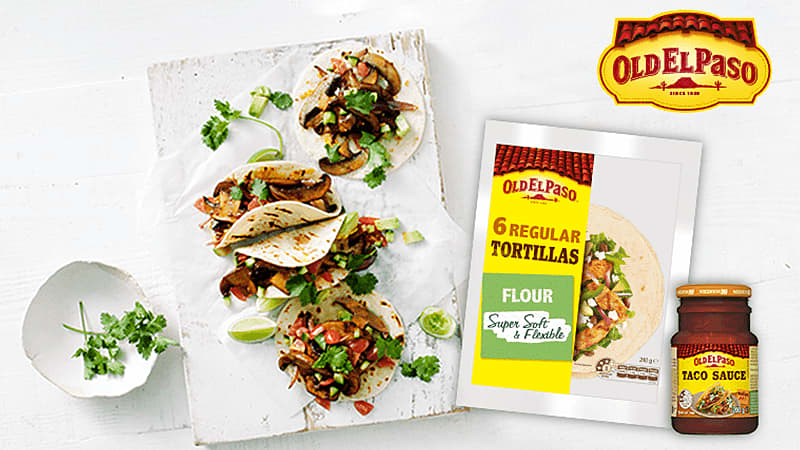 Mexi chipotle mushroom tacos served on white board accompanied by Old el paso's tortillas package & taco sauce jar