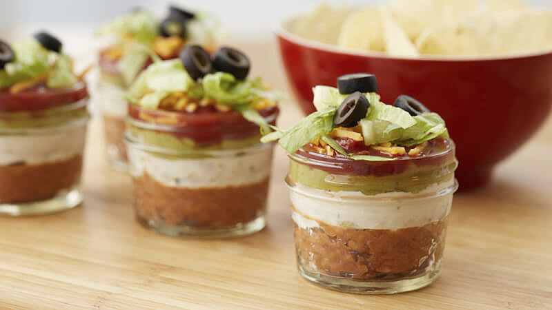 Mini bocaux en verre avec 7 couches de trempettes sur une planche de bois