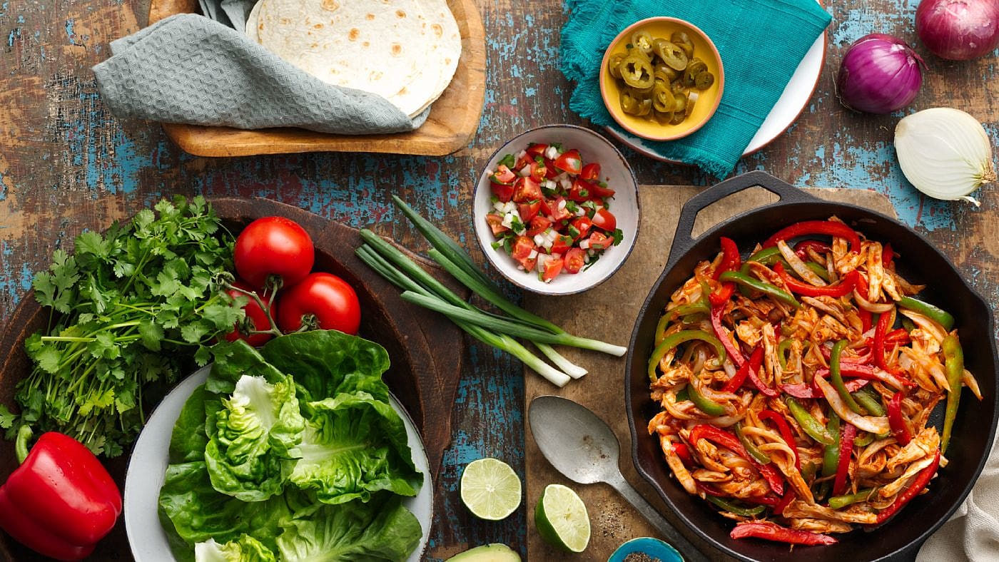 smoky BBQ fajita chicken recipe with a spread of fresh ingredients on the table