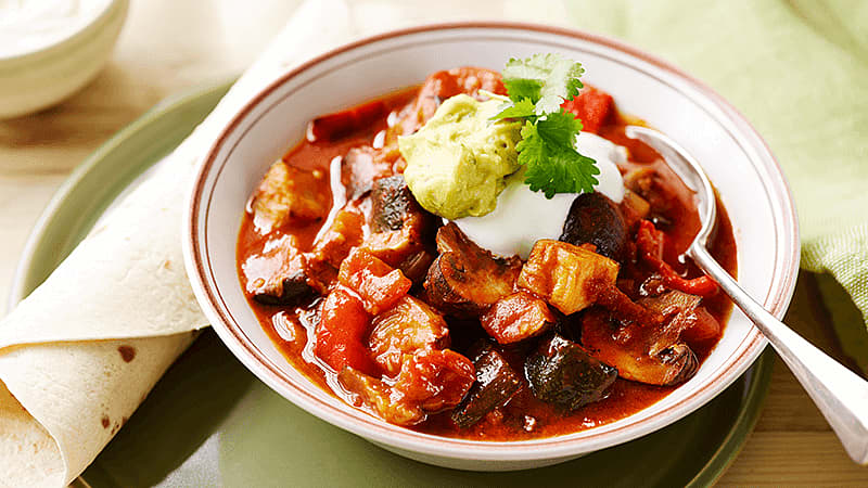 roasted vegetable chilli served in a bowl with tortilla wrap