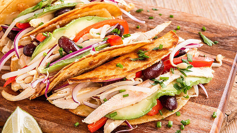 Poached Chicken Birria Tacos on rustic wooden board