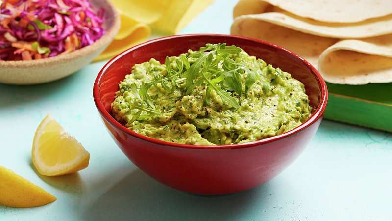 Tangy Lemon & Rocket Guacamole served in a red bowl