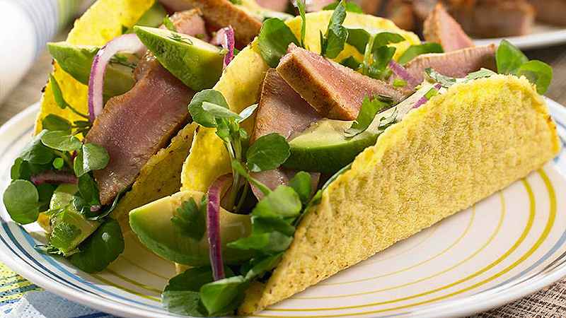 tuna taco salad garnished with fresh coriander served on white plate
